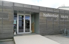 Eingang des Hallenbads mit Sauna in Scheiblingkirchen mit Holzvertäfelung und der Aufschrift "hallenbad sauna"