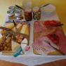 Breakfast buffet with cheese, cold cuts, tomatoes and peppers on wooden boards.