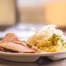 Ein Teller mit Fleisch, Sauerkraut und Kartoffelpüree.