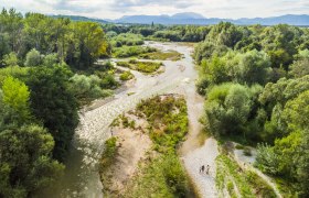 Aerial view of the source of the Leitha in Lanzenkirchen with river and green vegetation.