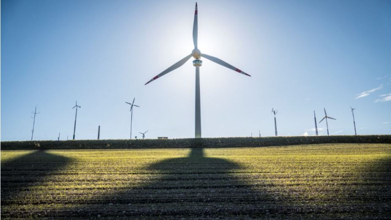 Windkraftanalge Lichtenegg und Kleinwindkraftanlagen auf einem Feld bei Sonnenuntergang.