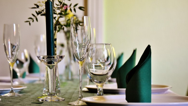 Elegant table with wine glasses, candle and folded napkins.