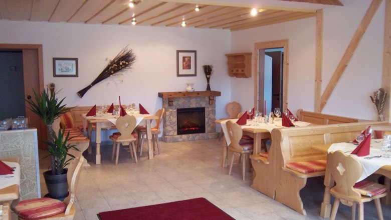 Gemütlicher Gastraum mit Holzmöbeln und Kamin.