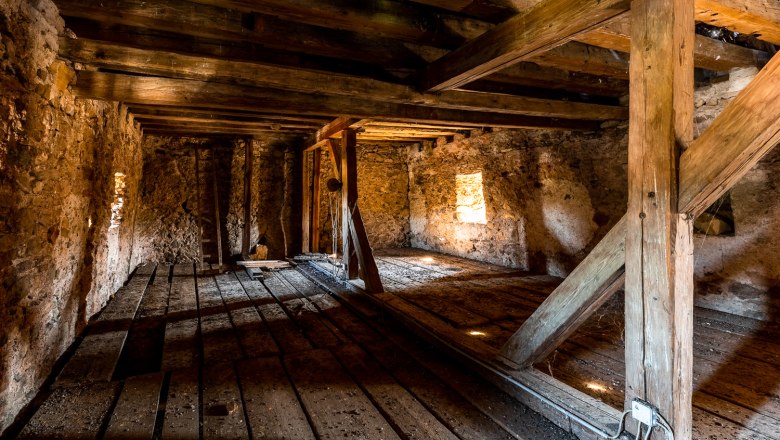 Interior view of the upper floor of the fortified church with wooden beams and stone walls.