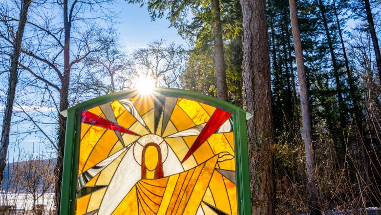 Von der Sonne beleuchtetes Buntglasfenster im Wald