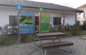 Ein Rastplatz mit Infotafeln für Wanderer und Radfahrer in Pitten.