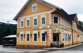Yellow building with the inscription 'Restaurant Pizzeria Zum Spitz'.