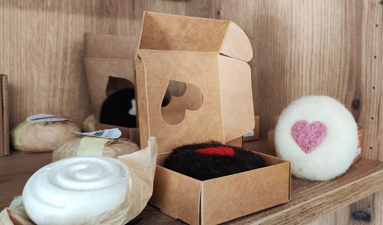 Handmade soaps and decorations with heart motifs on a shelf.