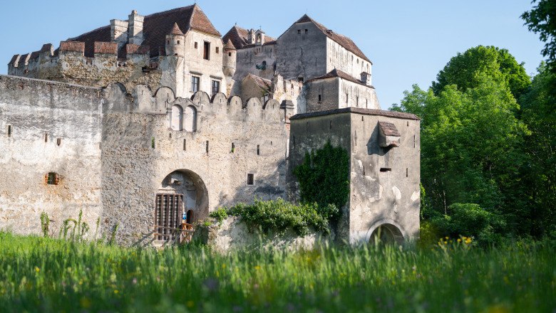 Burg Seebenstein mit gr&uuml;ner Wiese im Vordergrund und B&auml;umen im Hintergrund.