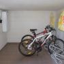 Fahrradraum mit zwei Fahrrädern und Werbeschildern an der Wand.