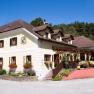 Traditional inn with yellow facade, many windows and terrace.