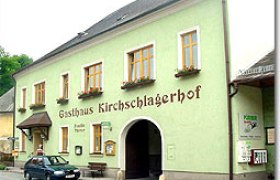 Ein traditionelles Gasthaus mit grüner Fassade und der Aufschrift 'Gasthaus Kirschlagerhof'.