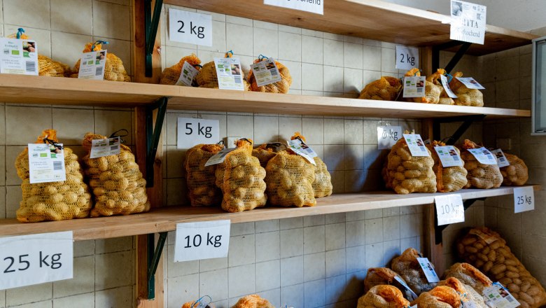 Verkaufsraum mit Regalen mit Kartoffelsäcken in verschiedenen Gewichtseinheiten.