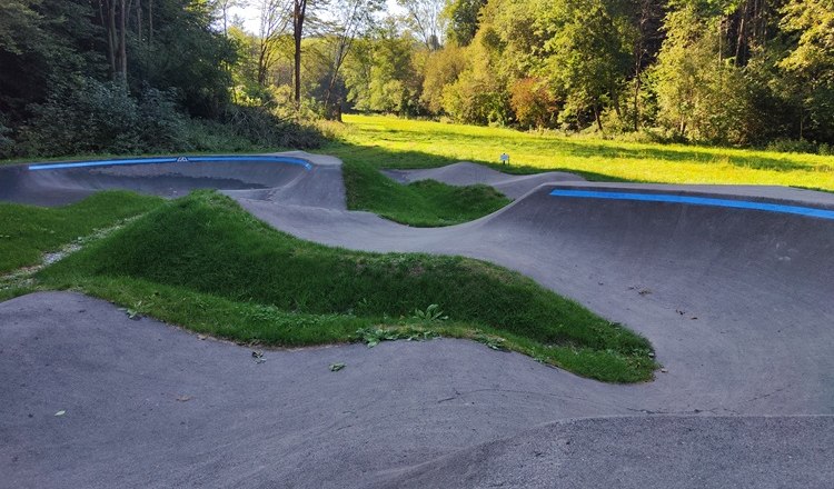 Pump track in Bad Schönau with green surroundings and trees in the background.