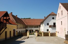 Innenhof des Dominikalhofs Bromberg mit historischen Gebäuden und roten Ziegeldächern.