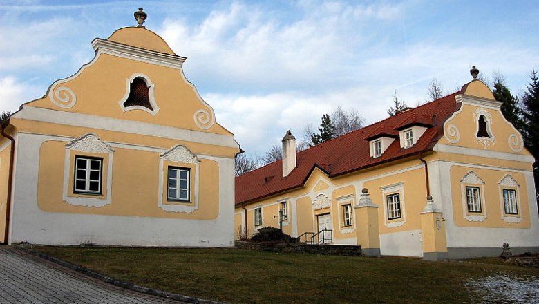 Historischer Pfarrhof Krumbach mit gelben Fassaden und roten Dächern.