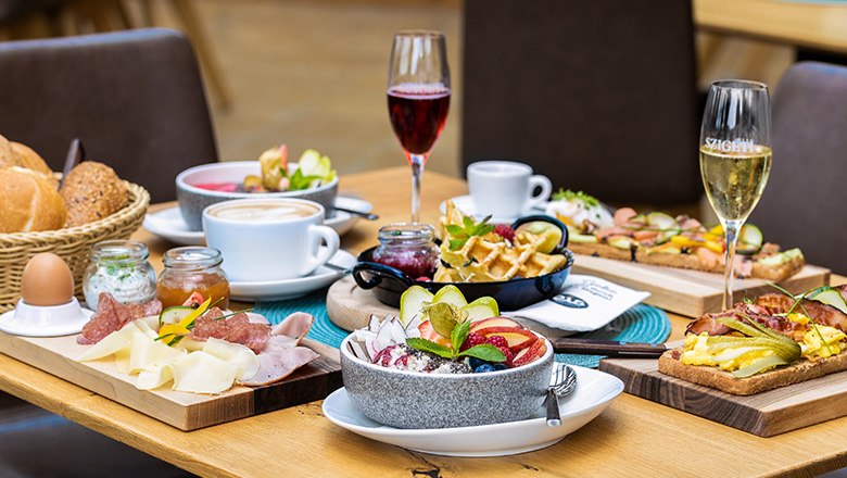 Fr&uuml;hst&uuml;ckstisch mit verschiedenen Speisen, Sektgl&auml;sern und Kaffee.