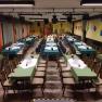 A large hall with long, laid tables and chairs, ready for an event.