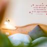 Gemütliches Schlafzimmer mit Zitat an der Wand und Holzkopfteil.