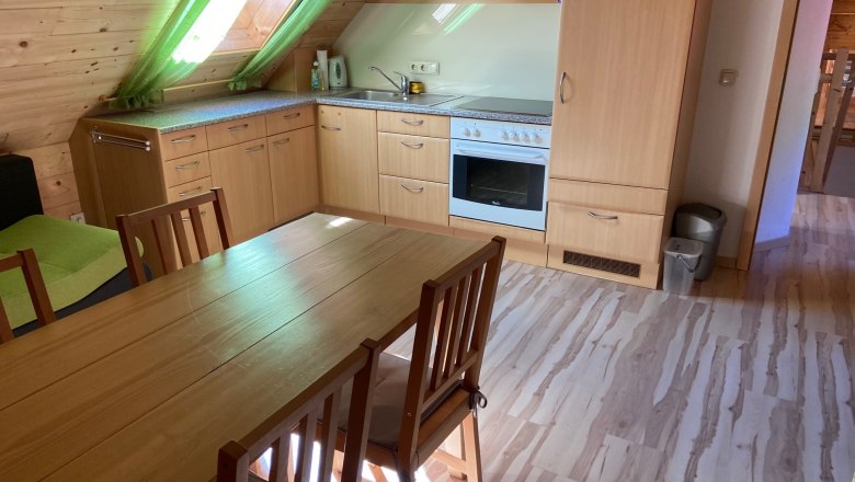 Kitchen in a vacation apartment with wooden furniture and skylight.