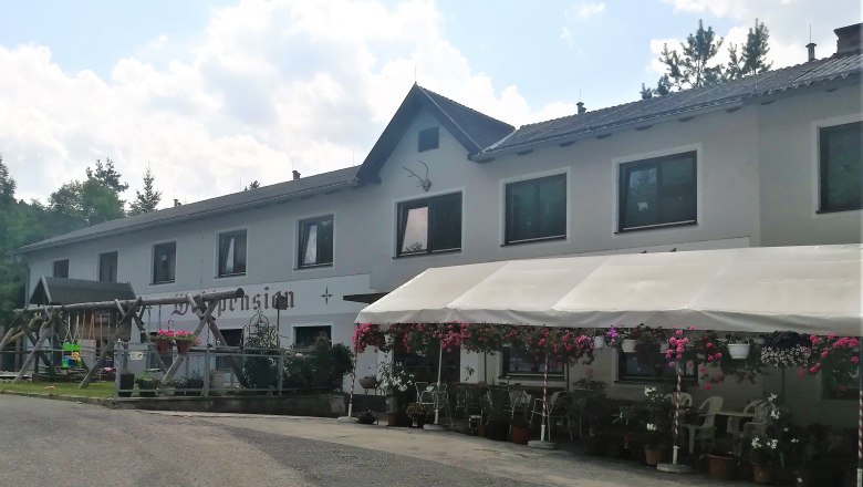 Waldpension Stachl, © Wiener Alpen Ein zweistöckiges Gebäude mit der Aufschrift 'Waldpension', umgeben von Blumen und einem Vordach.
