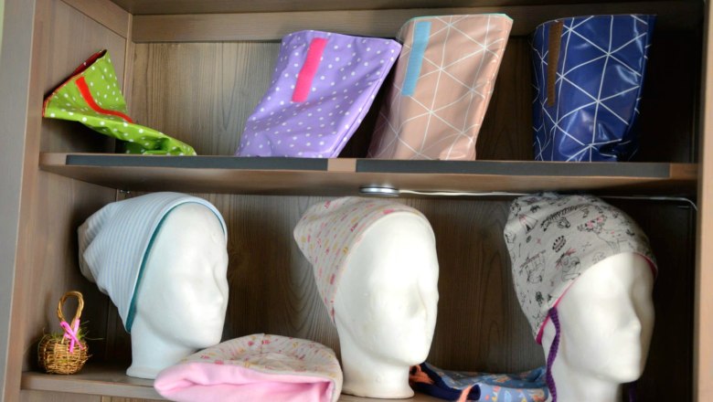 Regal mit handgemachten Mützen und Taschen.