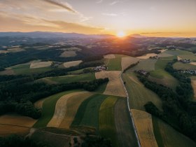 Luftaufnahme einer h&uuml;geligen Landschaft bei Sonnenuntergang