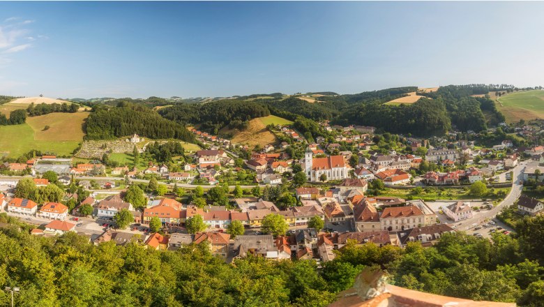 Panoramablick auf Kirchschlag in der Buckligen Welt mit Kirche und umliegenden Hügeln.